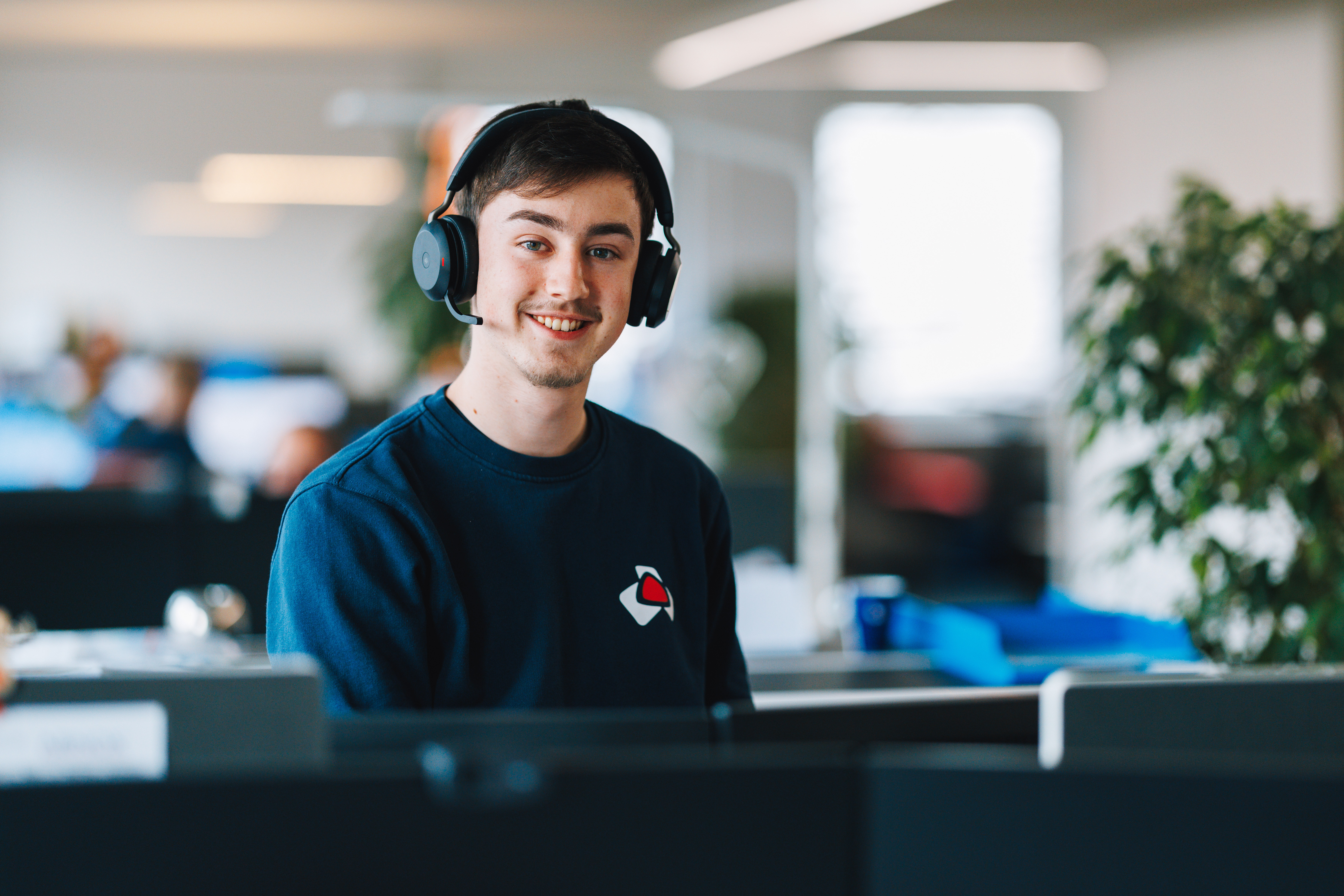 Junger Mann mit Headset am Arbeitsplatz bei ABNOX